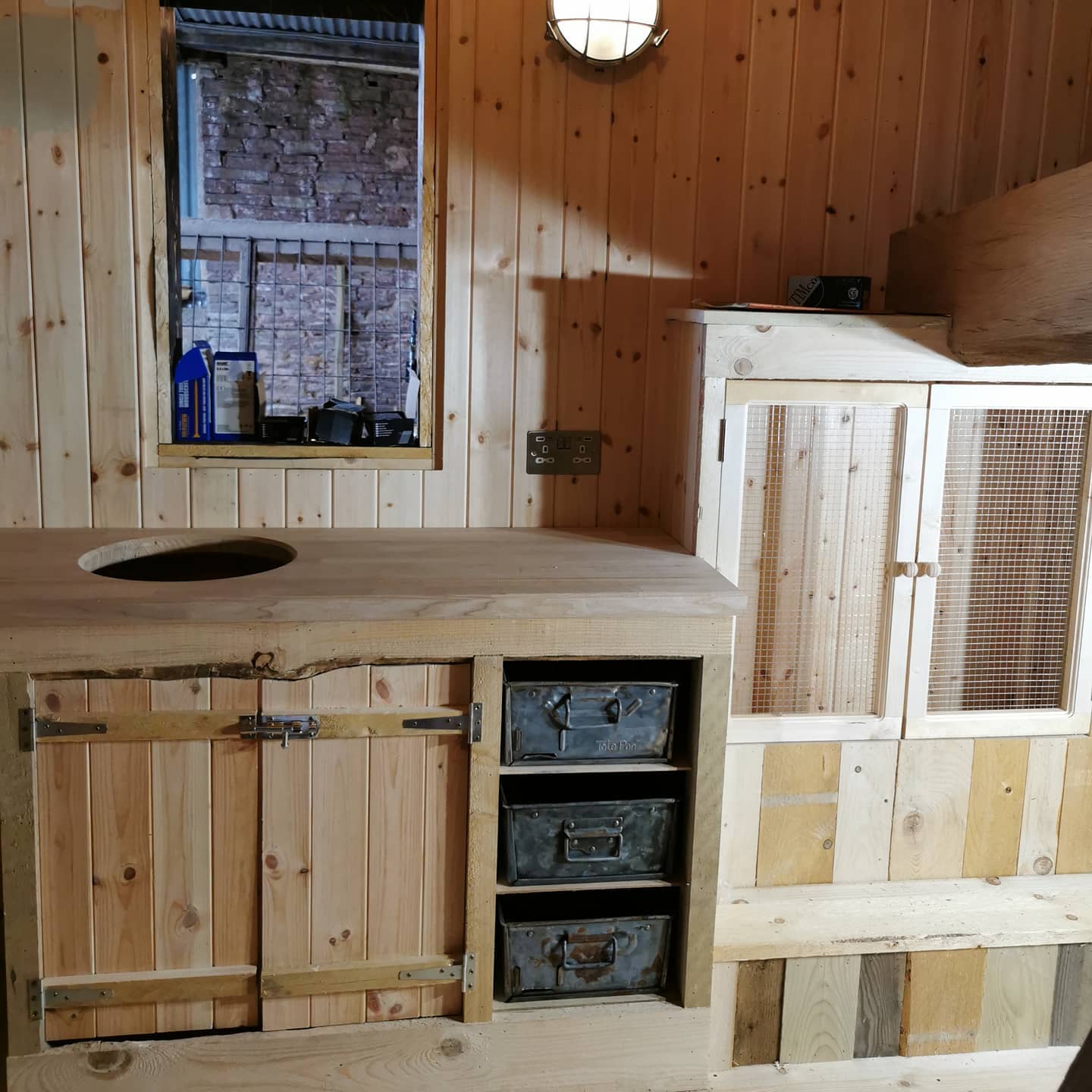 A wooden kitchen with a sink and drawers