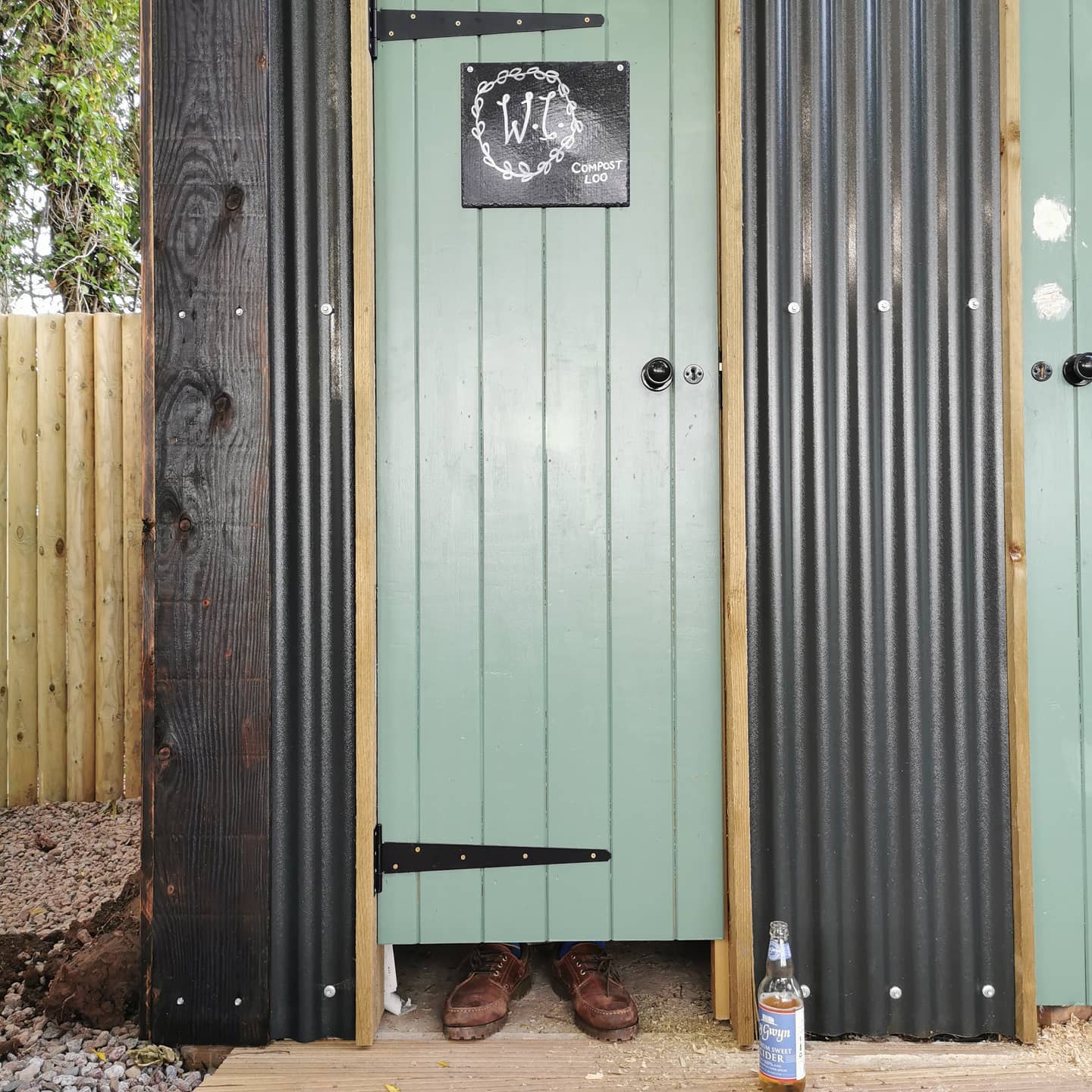A bottle of corona beer sits next to a green door