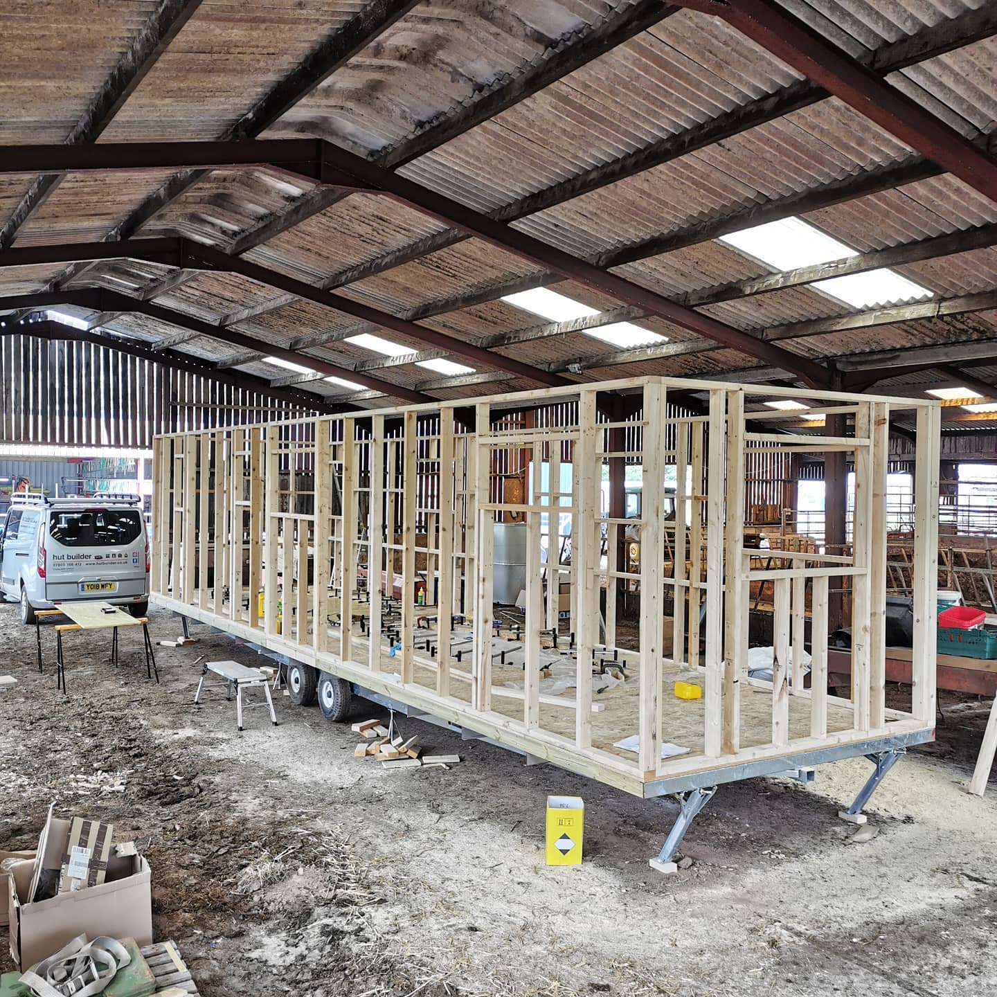 A large wooden structure is being built in a warehouse.