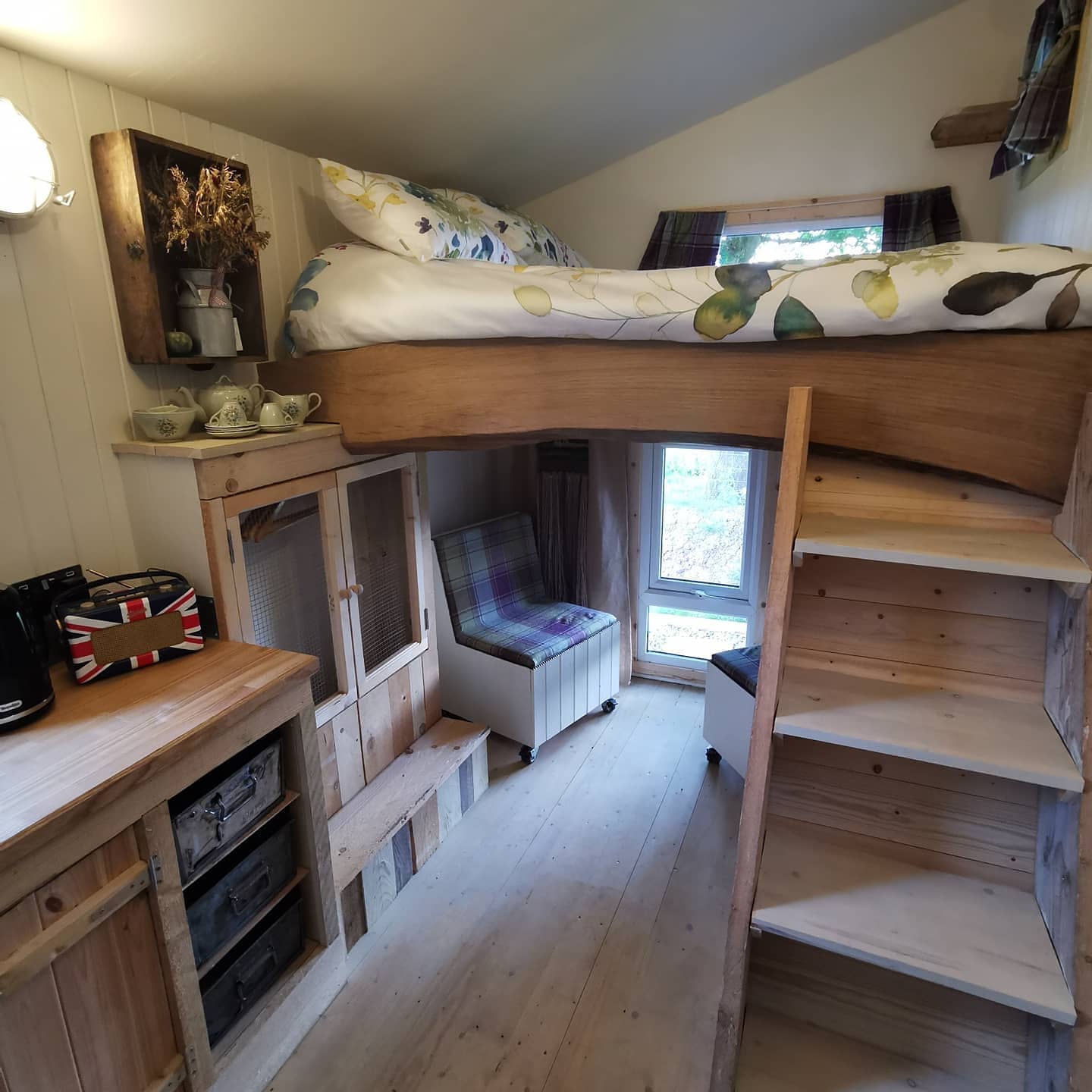 A bedroom with a bunk bed and stairs leading up to it