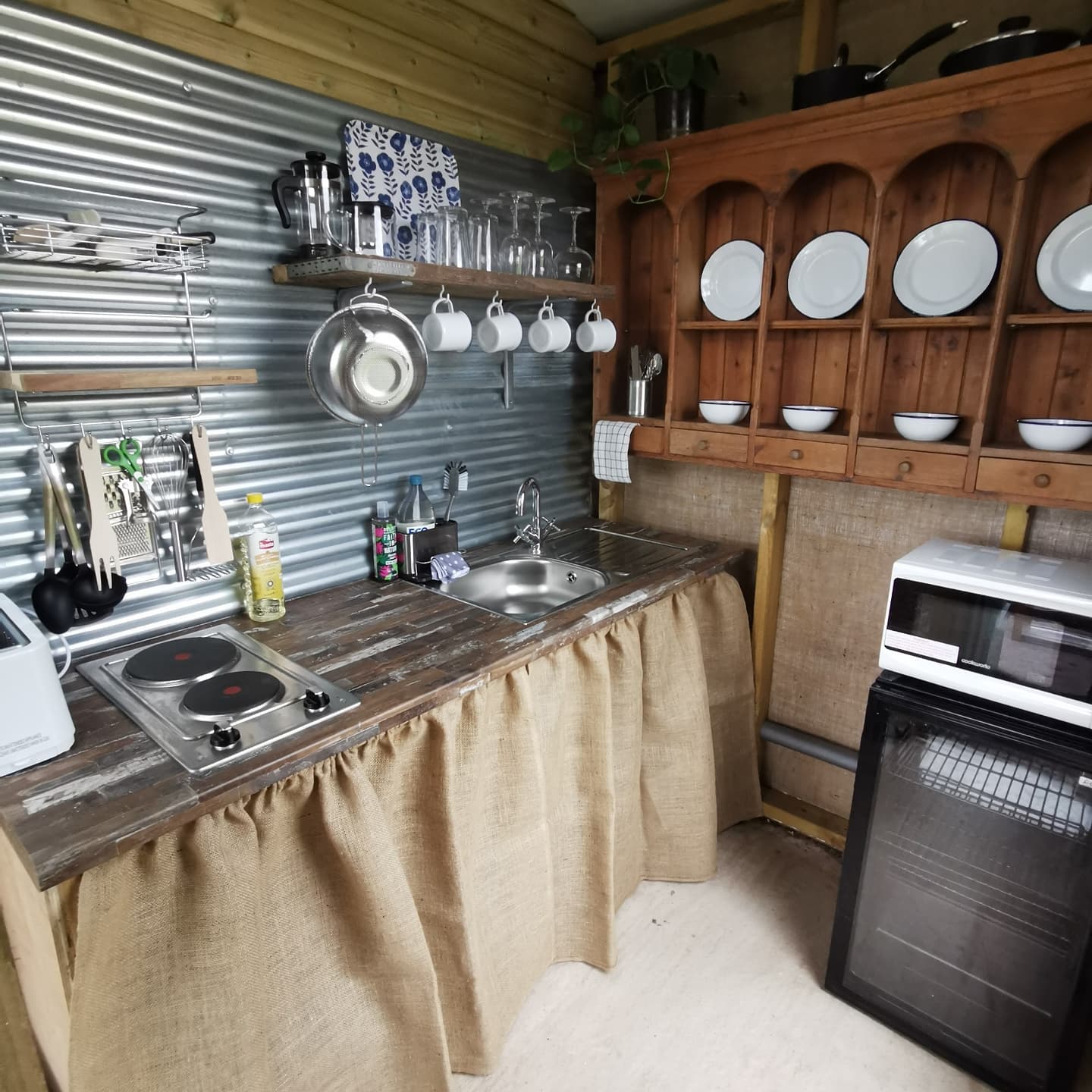 A kitchen with a stove a sink and a microwave