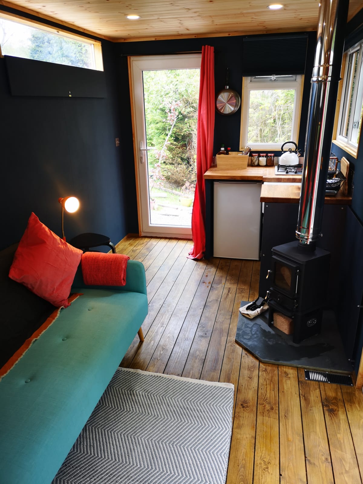 A living room with a blue couch and a wood stove