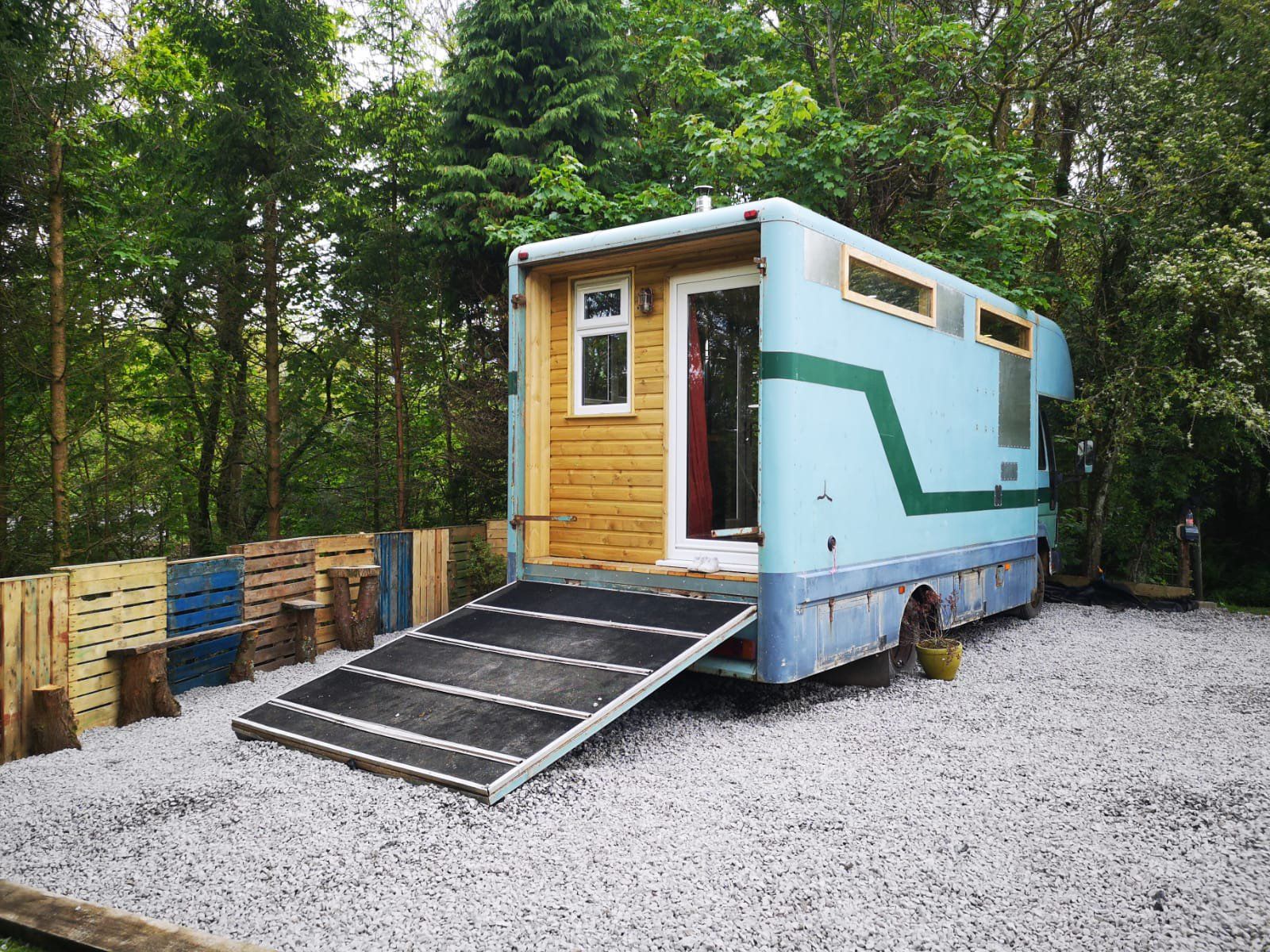 A tiny house made out of a shipping container with a ramp.