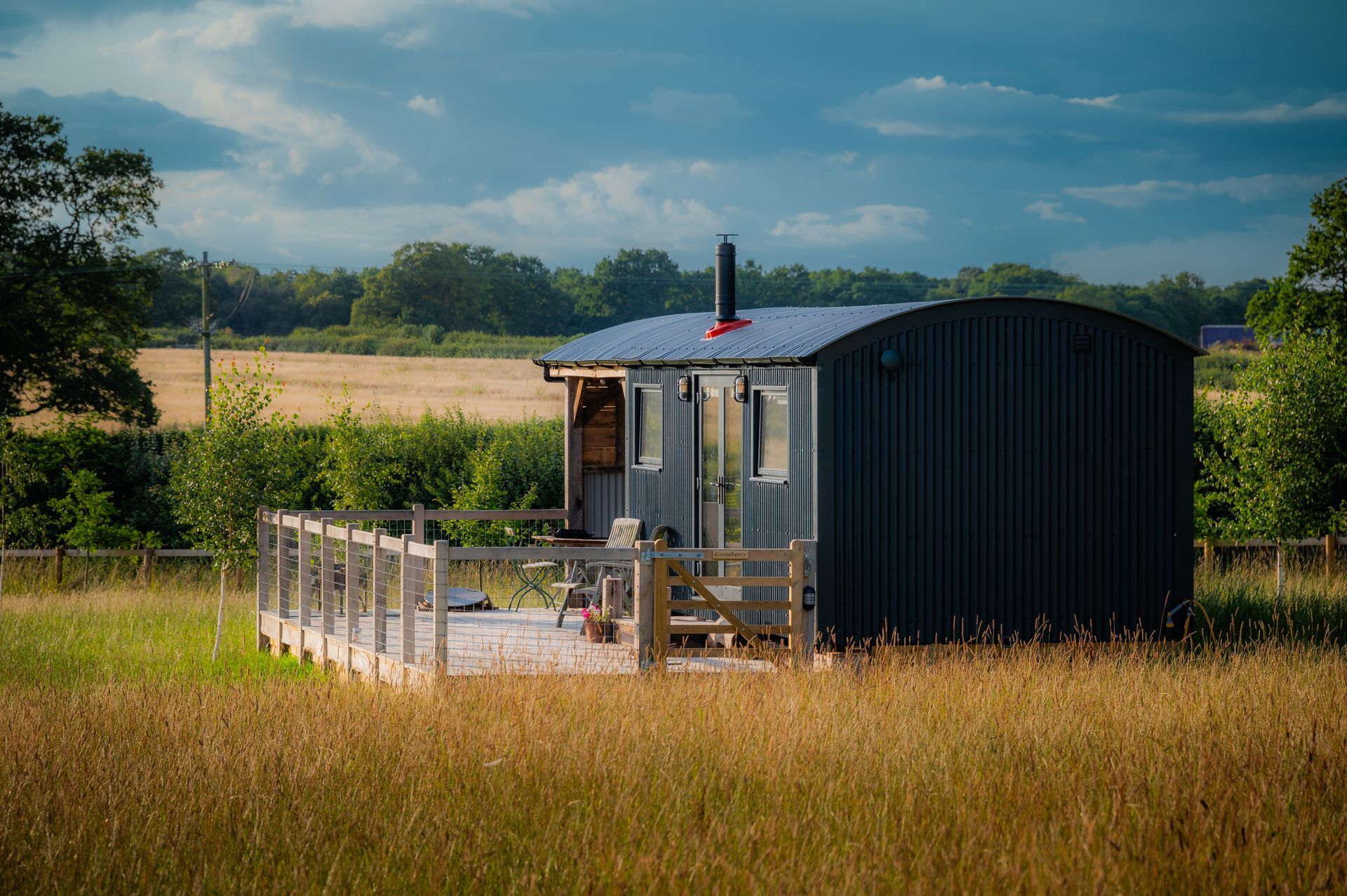 A small house is sitting in the middle of a field.
