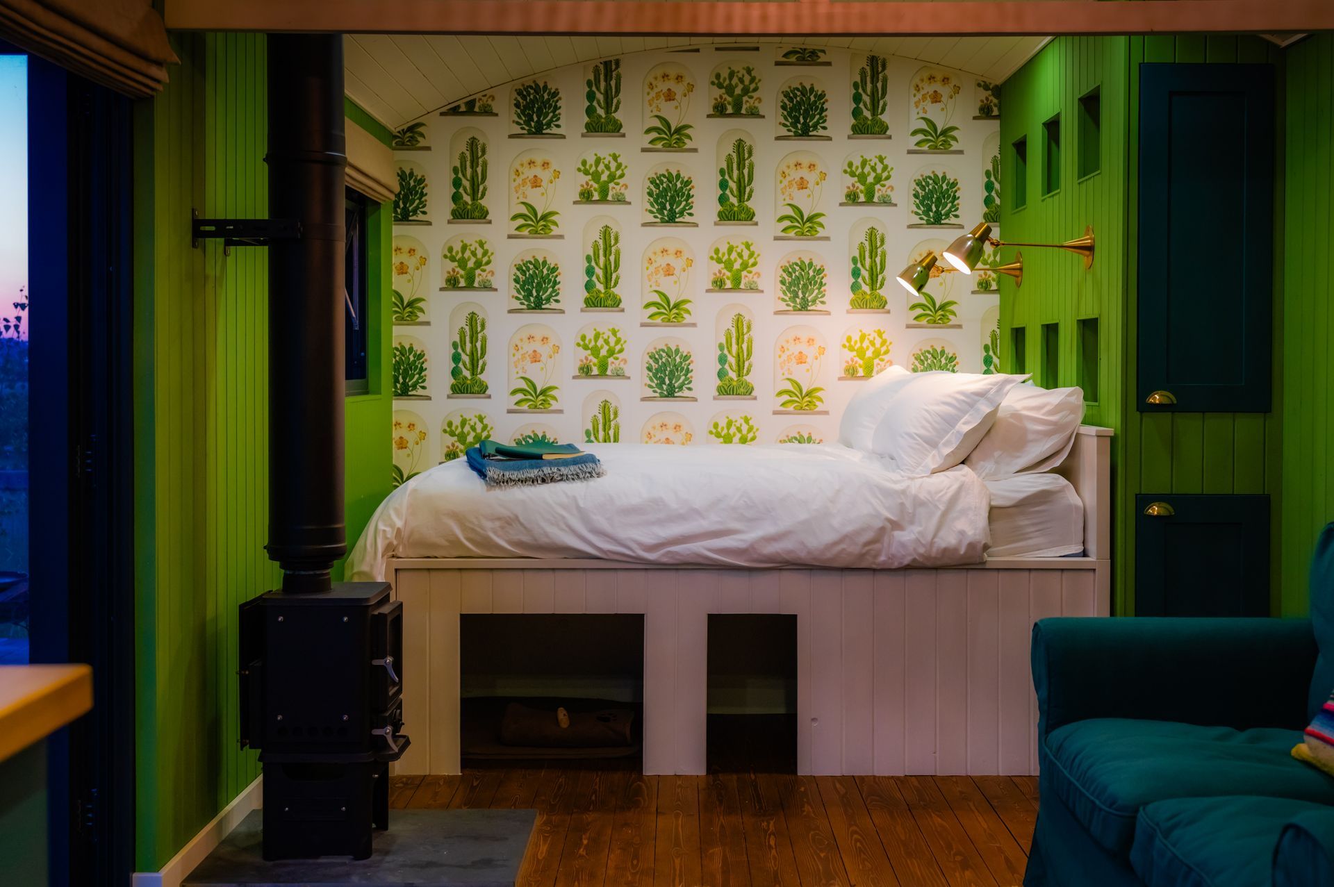 A bedroom with green walls and a bed with white sheets