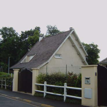 Une maison avec une clôture et une boîte aux lettres avec la lettre g dessus