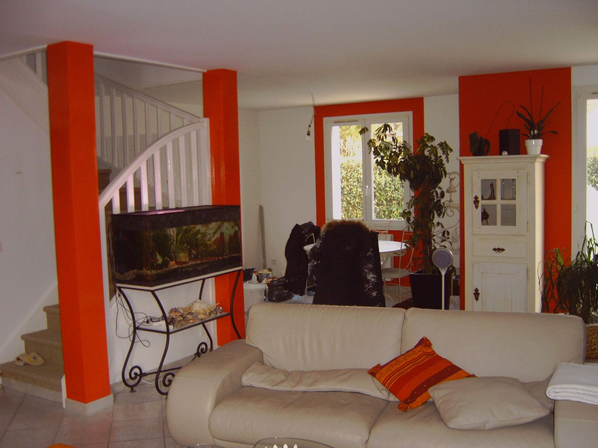 Un salon avec un canapé blanc et des murs orange