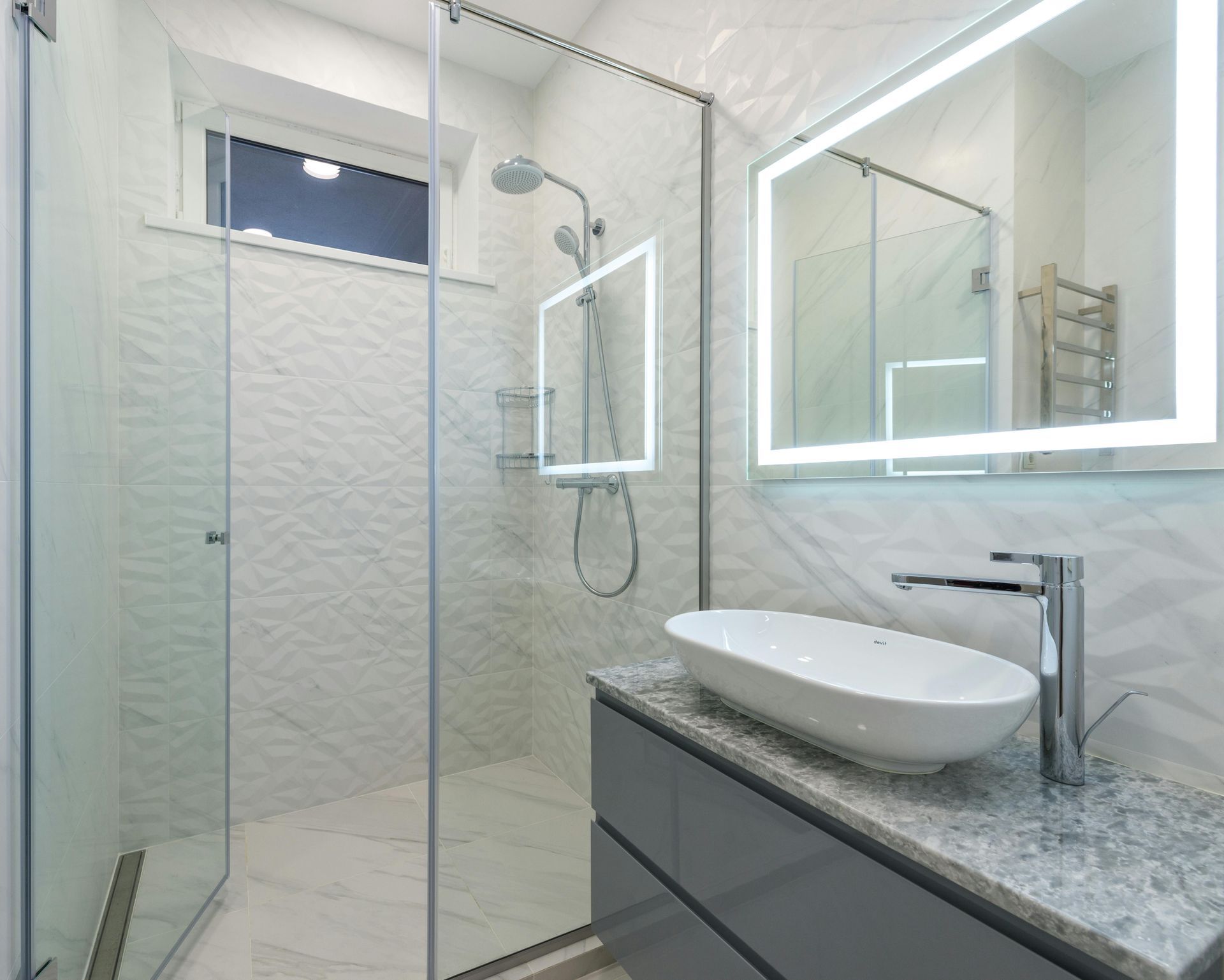 Modern white bathroom with glass shower, vanity, mirror cabinet, and granite countertop.