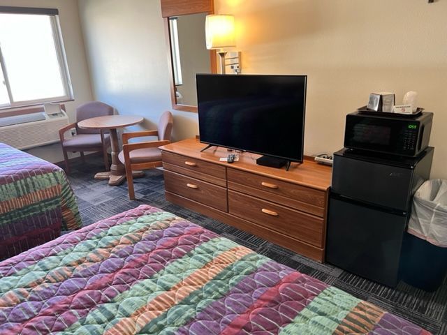 A motel room with two beds and a lamp.