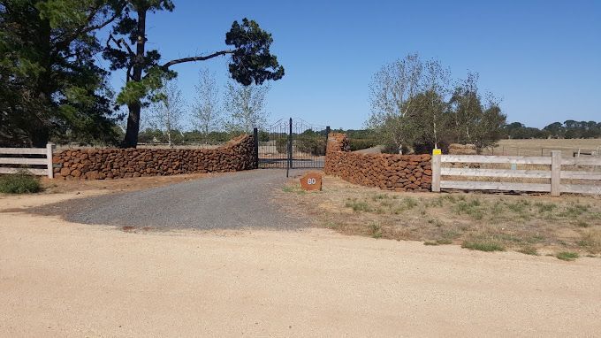 A chain link fence surrounds a wooden walkway in a park.