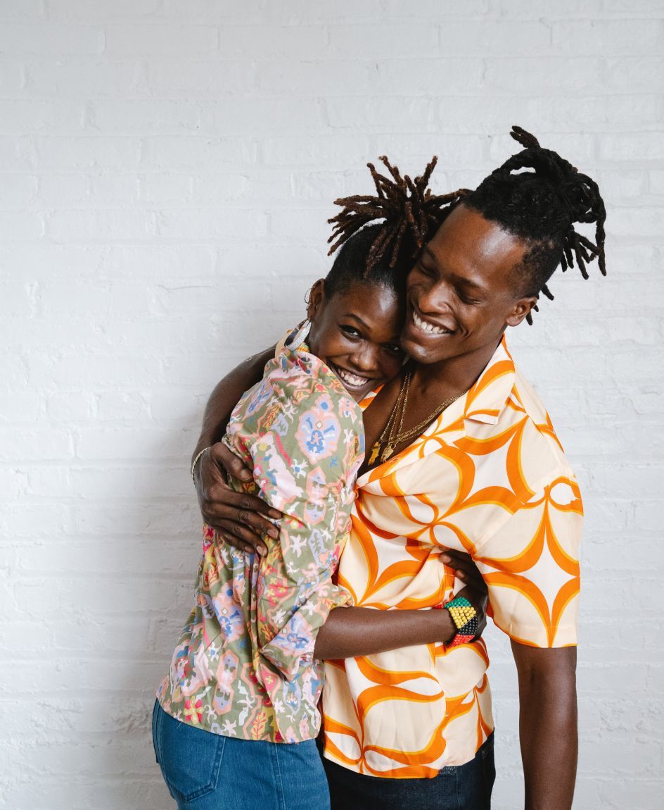 A man and a woman are hugging each other and smiling.