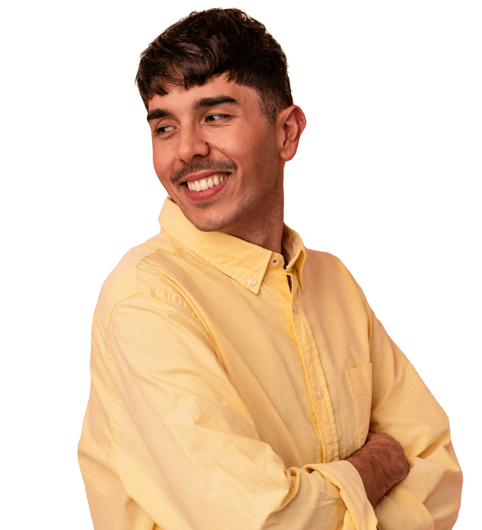 A man in a yellow shirt is smiling with his arms crossed