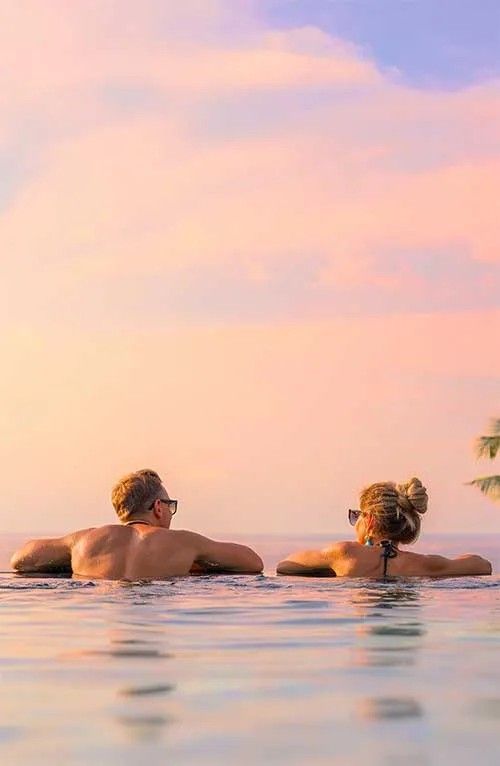 Couple by an infinity pool at sunset