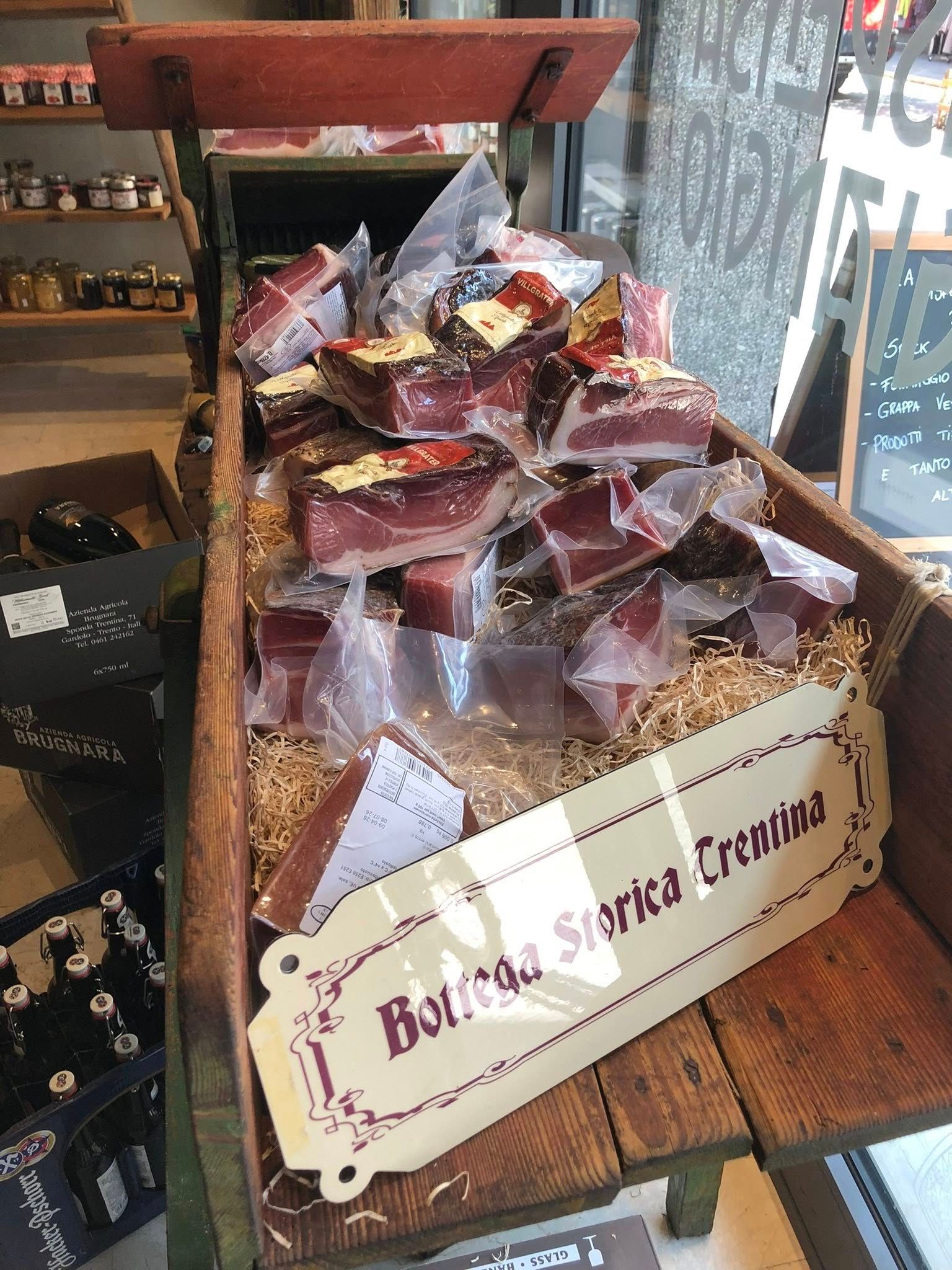 In un negozio, scaffali pieni di confezioni di tè in scatola, esposte su un supporto di legno.