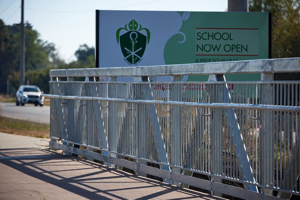 A Metal Pedestrian Bridge Railing in the Foreground With a Sign — Quarrell Civil Construction In Congupna, VIC