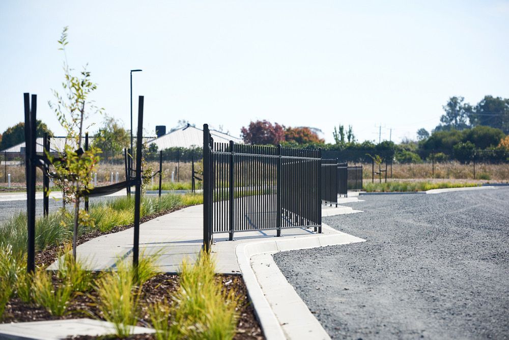 Black Metal Fencing Lines a Paved Sidewalk — Quarrell Civil Construction In Congupna, VIC