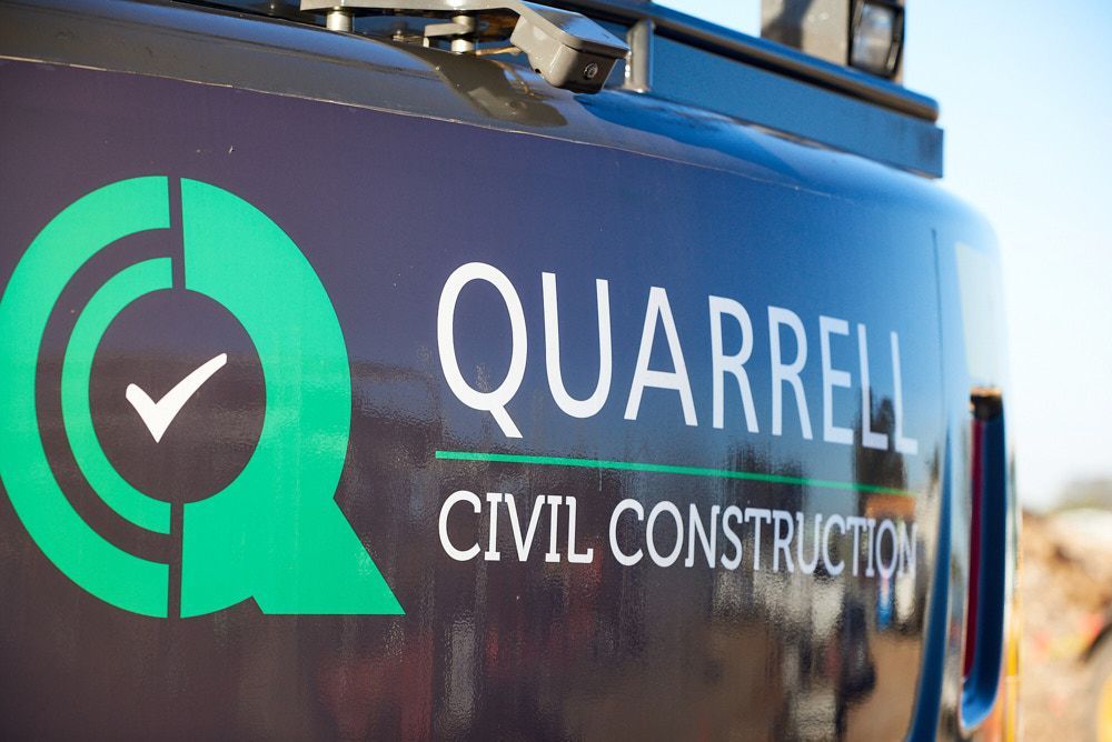 Quarrell Civil Construction Logo On A Dark Vehicle — Quarrell Civil Construction In Congupna, VIC