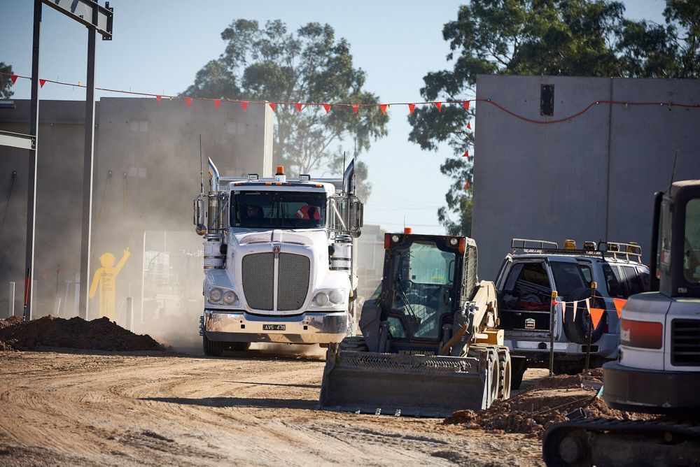 A White Kenworth Semi-truck Drives Through a Dusty Construction Site — Quarrell Civil Construction In Congupna, VIC