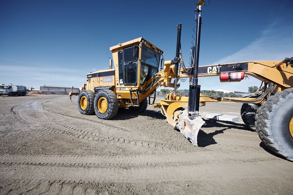 A Yellow Caterpillar Motor Grader Sits on a Dusty — Quarrell Civil Construction In Congupna, VIC