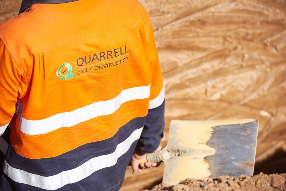 A Construction Worker in an Orange and Navy High-visibility Jacket — Quarrell Civil Construction In Congupna, VIC