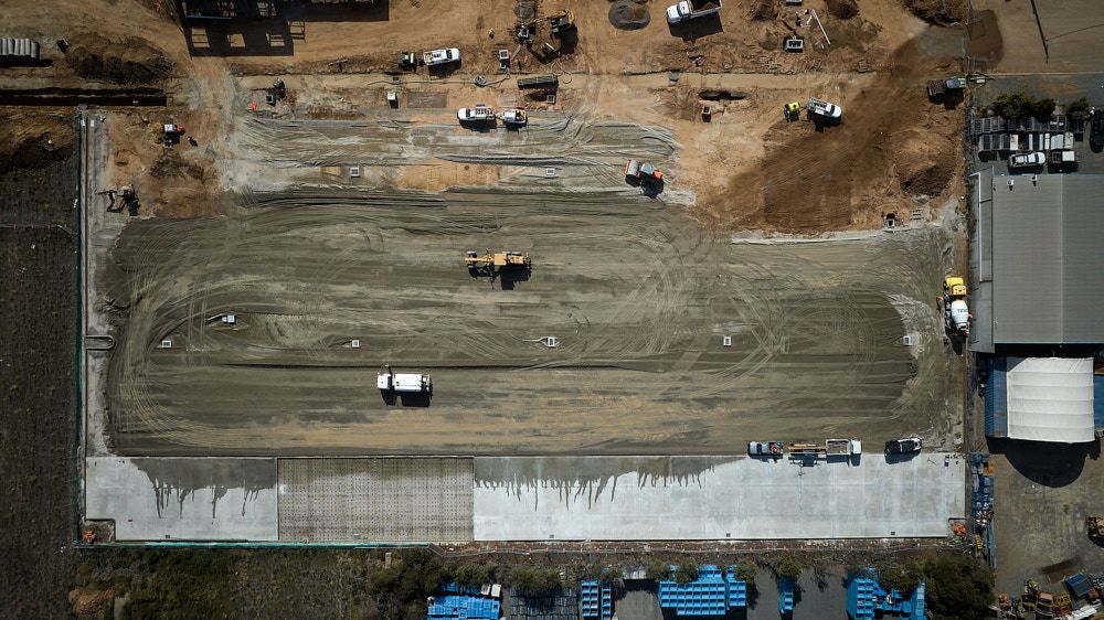 Aerial View of a Construction Site Featuring a Large, Leveled Dirt Area, Heavy Machinery — Quarrell Civil Construction In Congupna, VIC