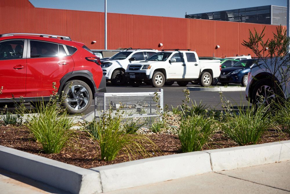 A Red Car and White Pickup Trucks Parked in a Lot — Quarrell Civil Construction In Congupna, VIC