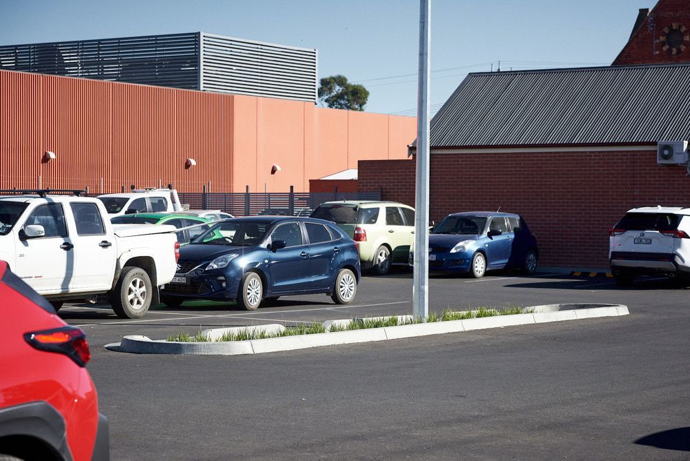 A Parking Lot With Several Parked Cars, Including White, Blue, and Silver Vehicles — Quarrell Civil Construction In Congupna, VIC