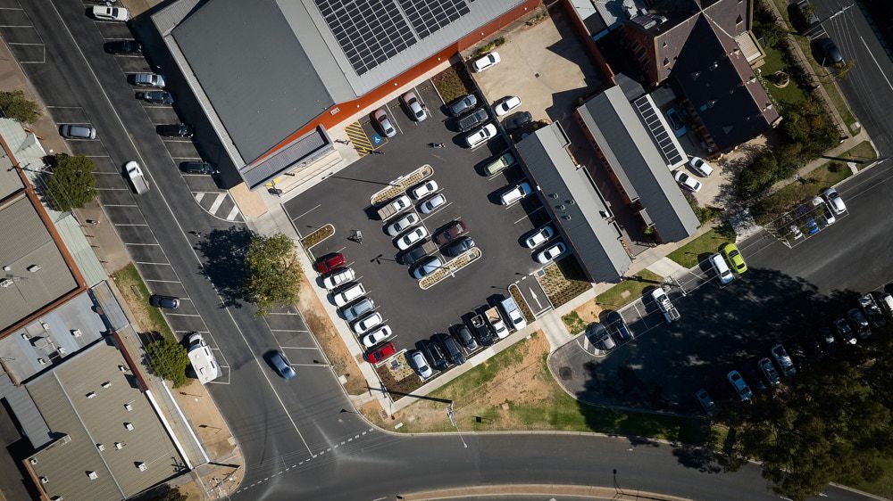 An Aerial View of a Parking Lot Next to a Building With Solar Panels — Quarrell Civil Construction In Congupna, VIC