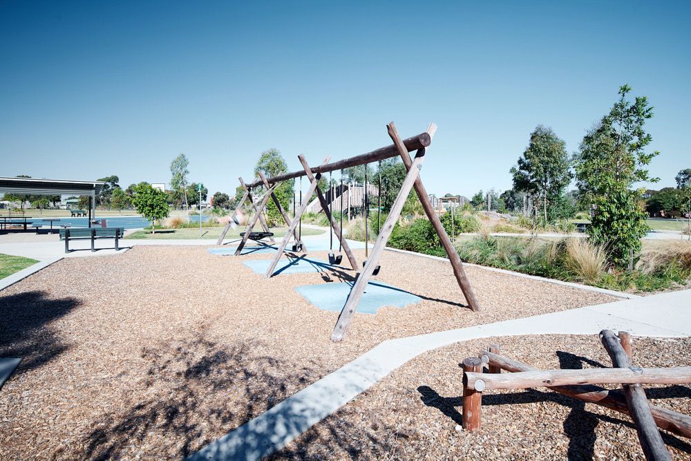 A Wooden Swing Set Stands in a Playground Covered — Quarrell Civil Construction In Congupna, VIC