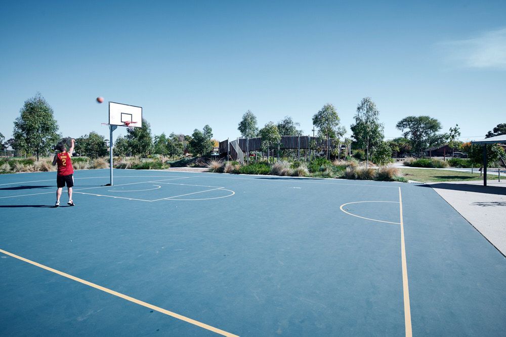 A Person in a Red Shirt Shoots a Basketball Toward a Hoop — Quarrell Civil Construction In Congupna, VIC