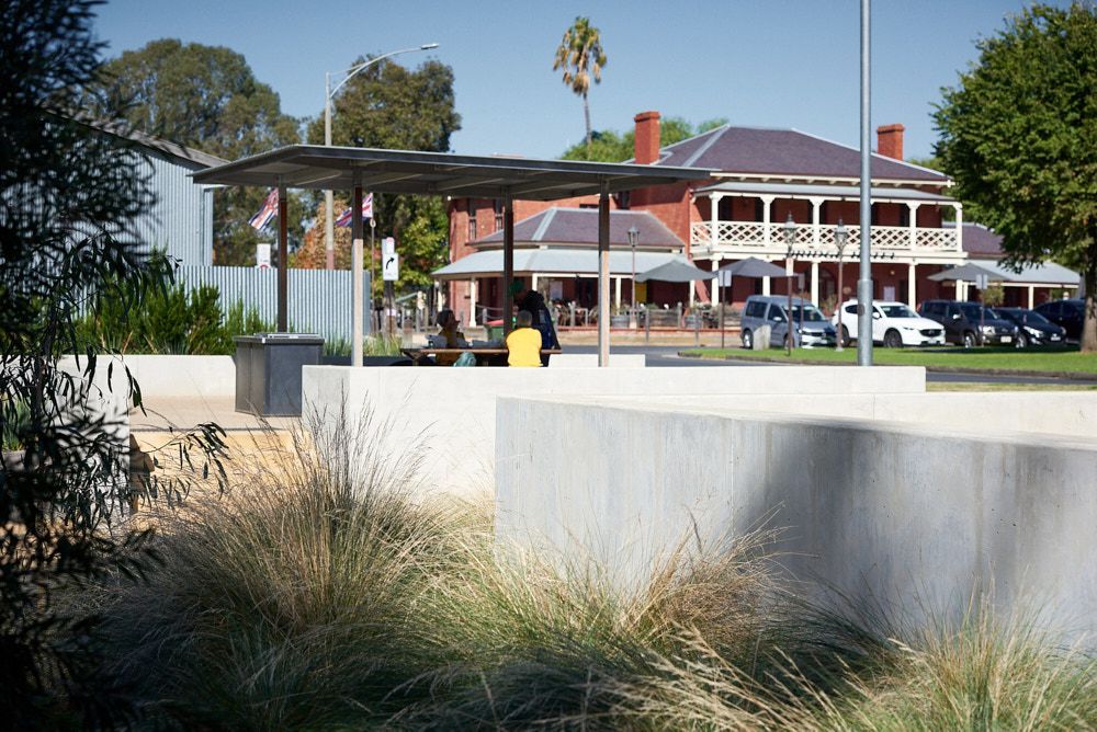 A Shaded Outdoor Area With a Picnic Table in Front of a Historic Two-story Brick Hotel — Quarrell Civil Construction In Congupna, VIC