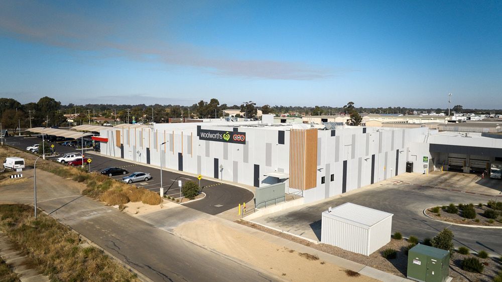 Warehouse Building With Black, Gray, And Brown Panels Under A Blue Sky — Quarrell Civil Construction In Congupna, VIC