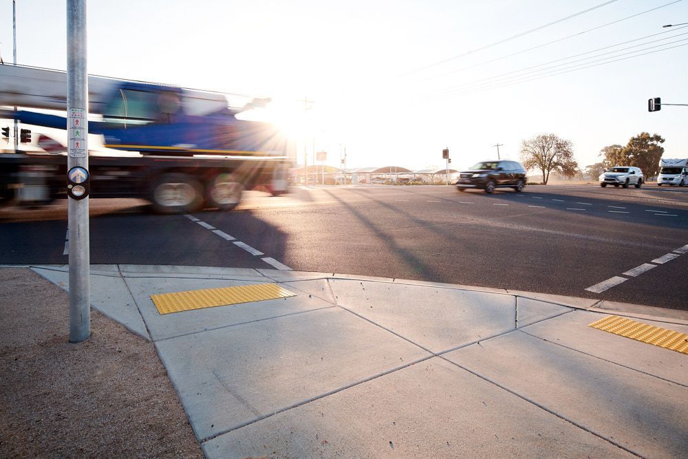 A Concrete Street Corner With Yellow Tactile Paving Markers — Quarrell Civil Construction In Congupna, VIC