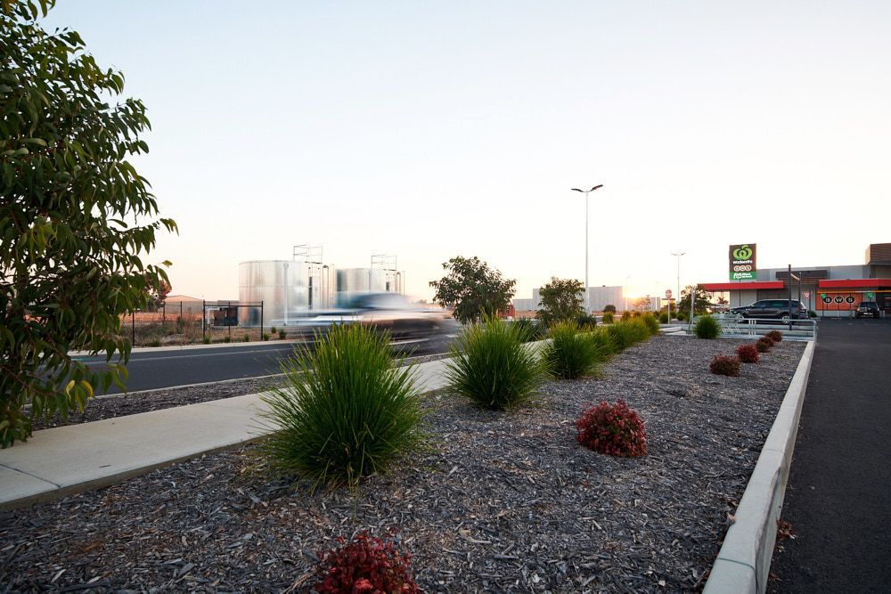 A Landscape Bed With Dark Mulch and Ornamental Grasses — Quarrell Civil Construction In Congupna, VIC