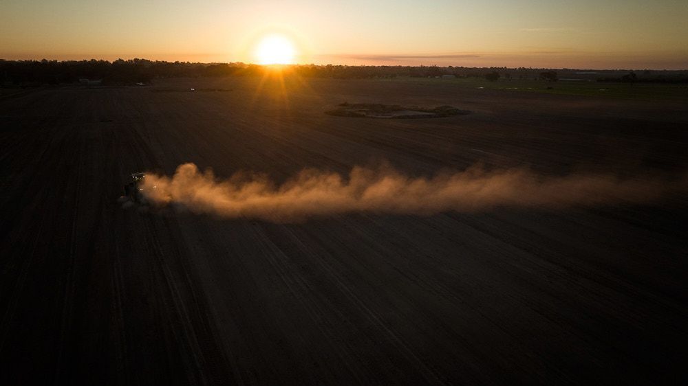 An Aerial View of Farm Machinery Kicking Up a Cloud of Dust — Quarrell Civil Construction In Congupna, VIC