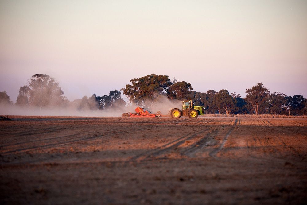 A Green Tractor Pulls Farm Equipment Through a Dry — Quarrell Civil Construction In Congupna, VIC