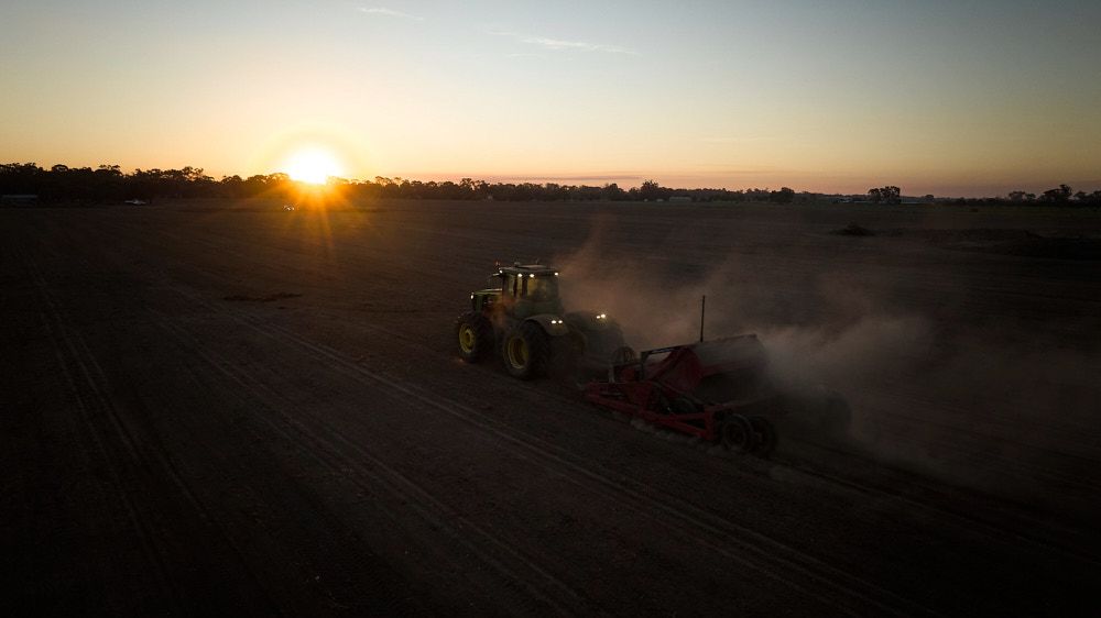 A Tractor Pulls Equipment Through a Dusty Field — Quarrell Civil Construction In Congupna, VIC