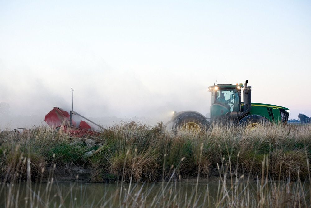A Green John Deere Tractor Pulling a Red Farm Implement — Quarrell Civil Construction In Congupna, VIC