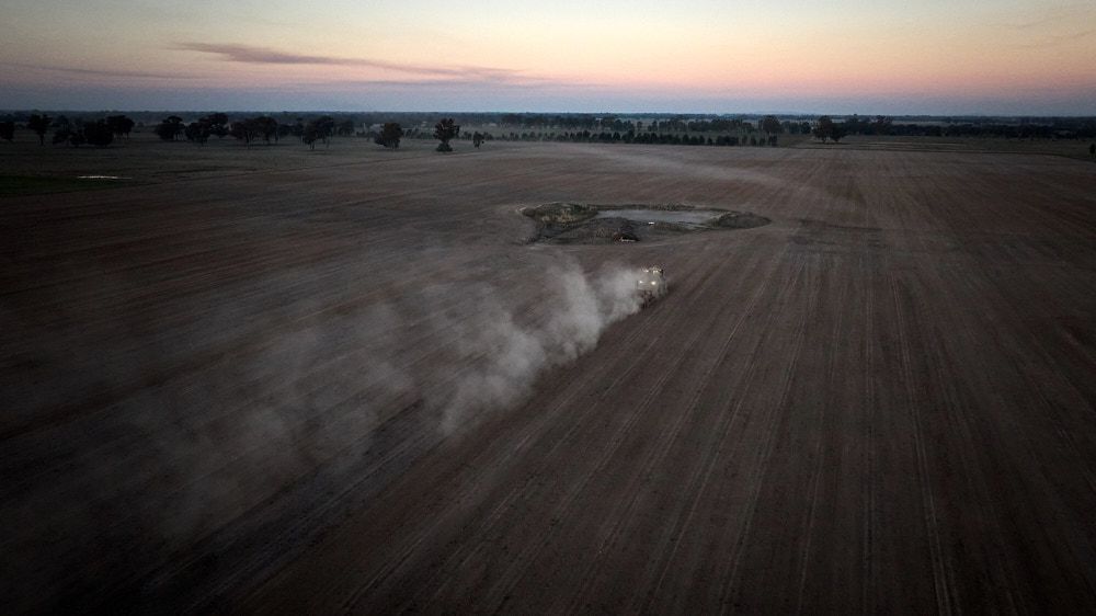 An Aerial View of a Vehicle Driving Through a Dry Field at Dusk — Quarrell Civil Construction In Congupna, VIC