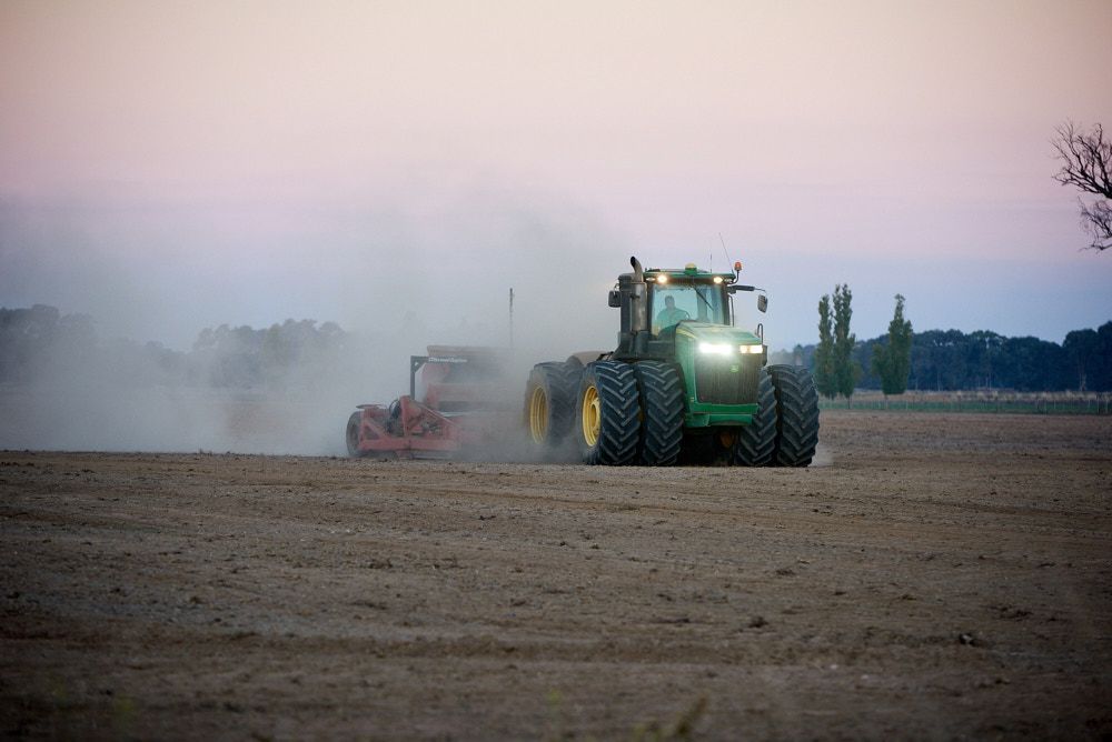 A Green Tractor With Dual Tires Pulls Equipment Across a Dusty — Quarrell Civil Construction In Congupna, VIC