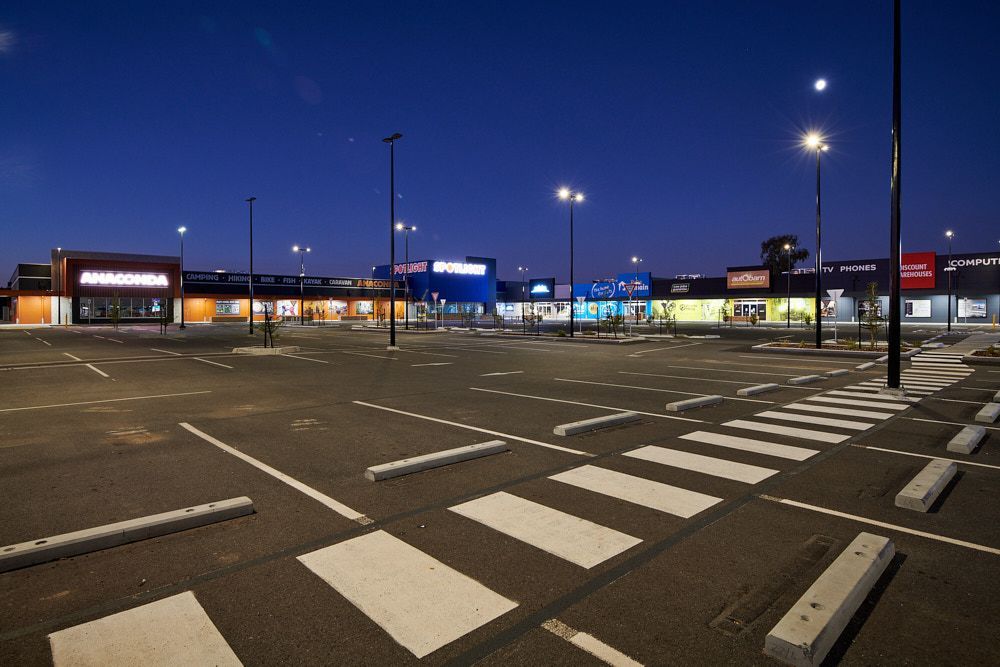 A Shopping Plaza Parking Lot at Dusk, With Storefronts Illuminated — Quarrell Civil Construction In Congupna, VIC
