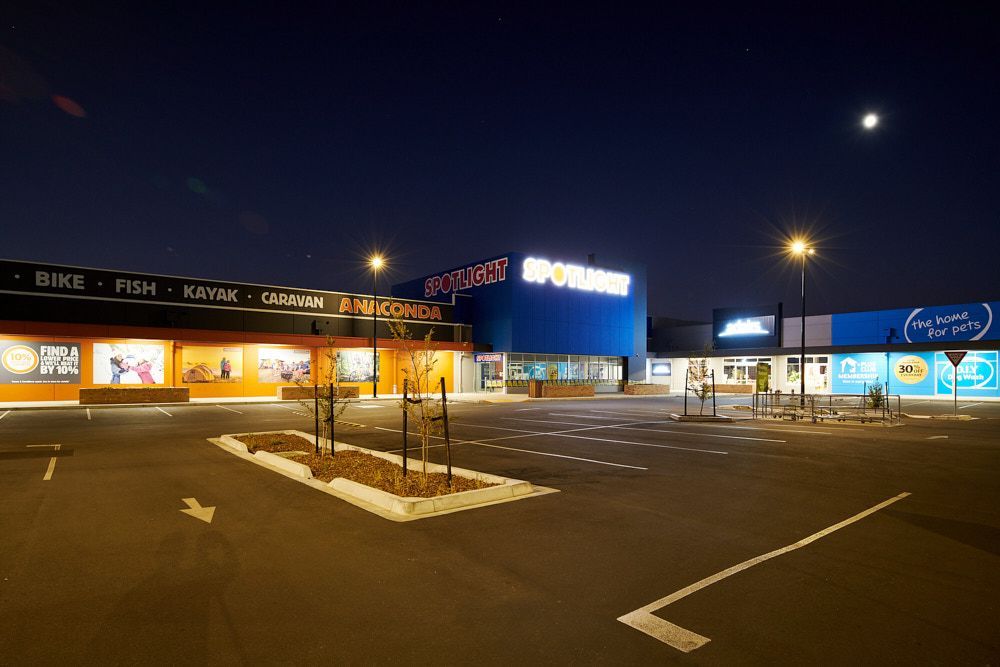 A Nighttime View of a Retail Shopping Center With a Parking Lot in the Foreground — Quarrell Civil Construction In Congupna, VIC