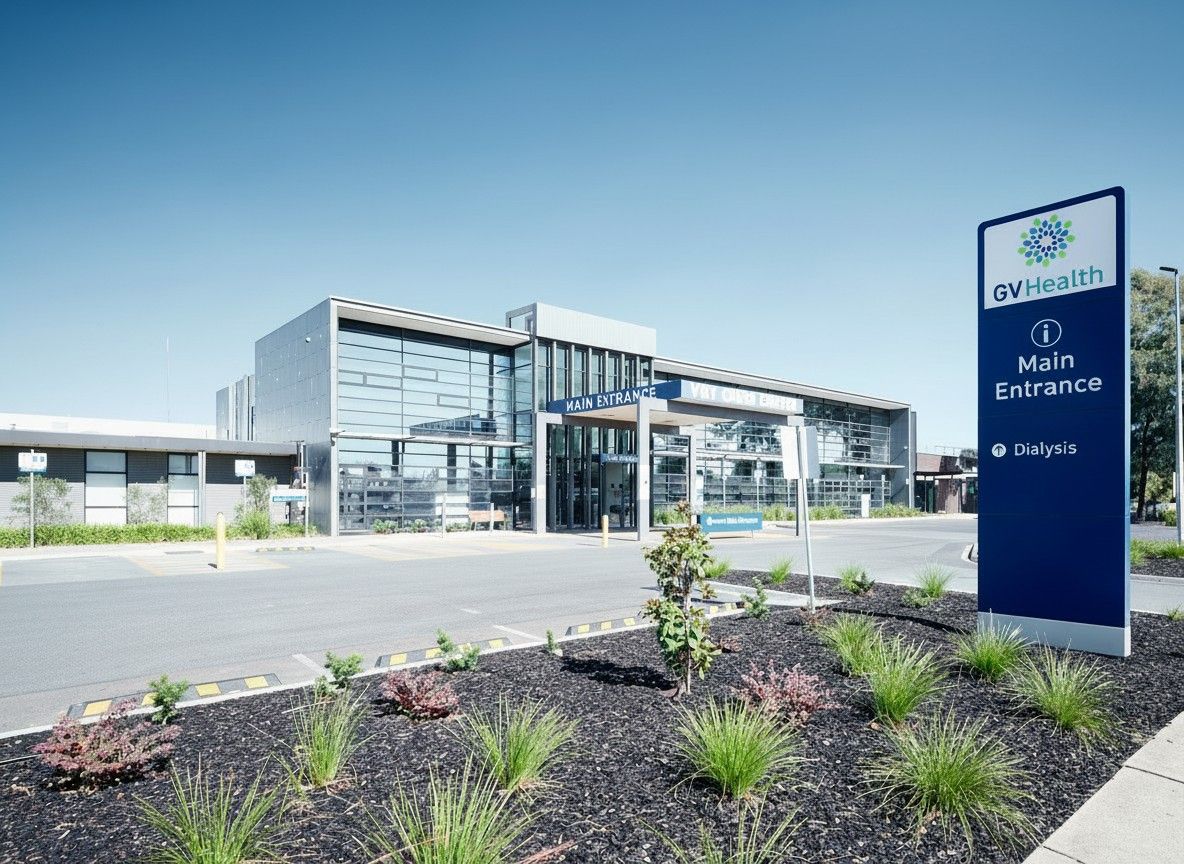 A modern GV Health hospital building with a blue signage pillar in the foreground on a sunny day — Quarrell Civil Construction In Congupna, VIC
