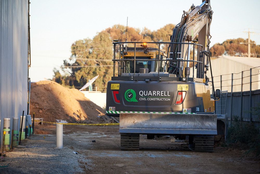 A Black Quarrell Construction Excavator Sits on a Dirt — Quarrell Civil Construction In Congupna, VIC