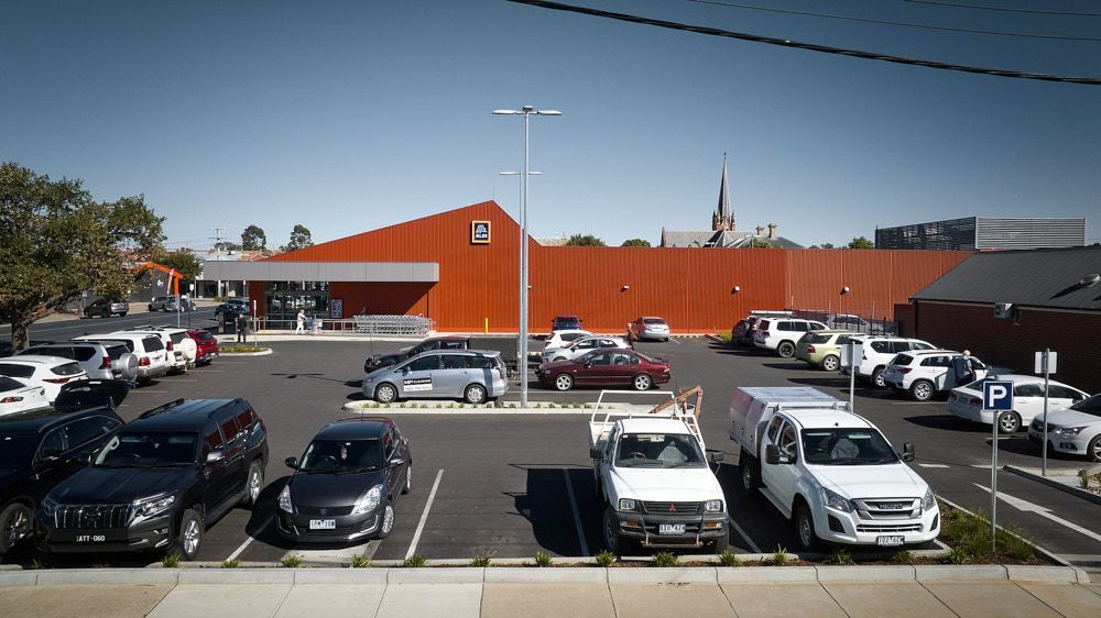 A Parking Lot in Front of a Modern Orange-red Building — Quarrell Civil Construction In Congupna, VIC