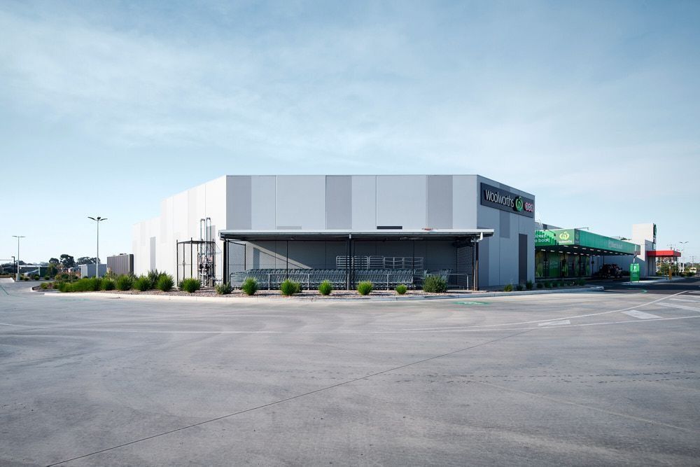 A Light-colored, Angular Retail Building With a Parking Lot — Quarrell Civil Construction In Congupna, VIC
