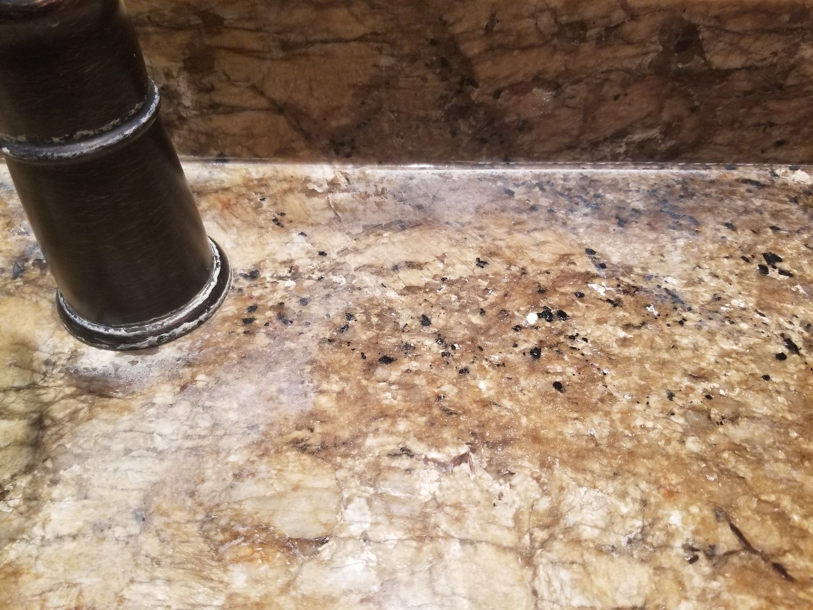 Granite vanity with white hard water crust around the faucet before cleaning, Needham MA