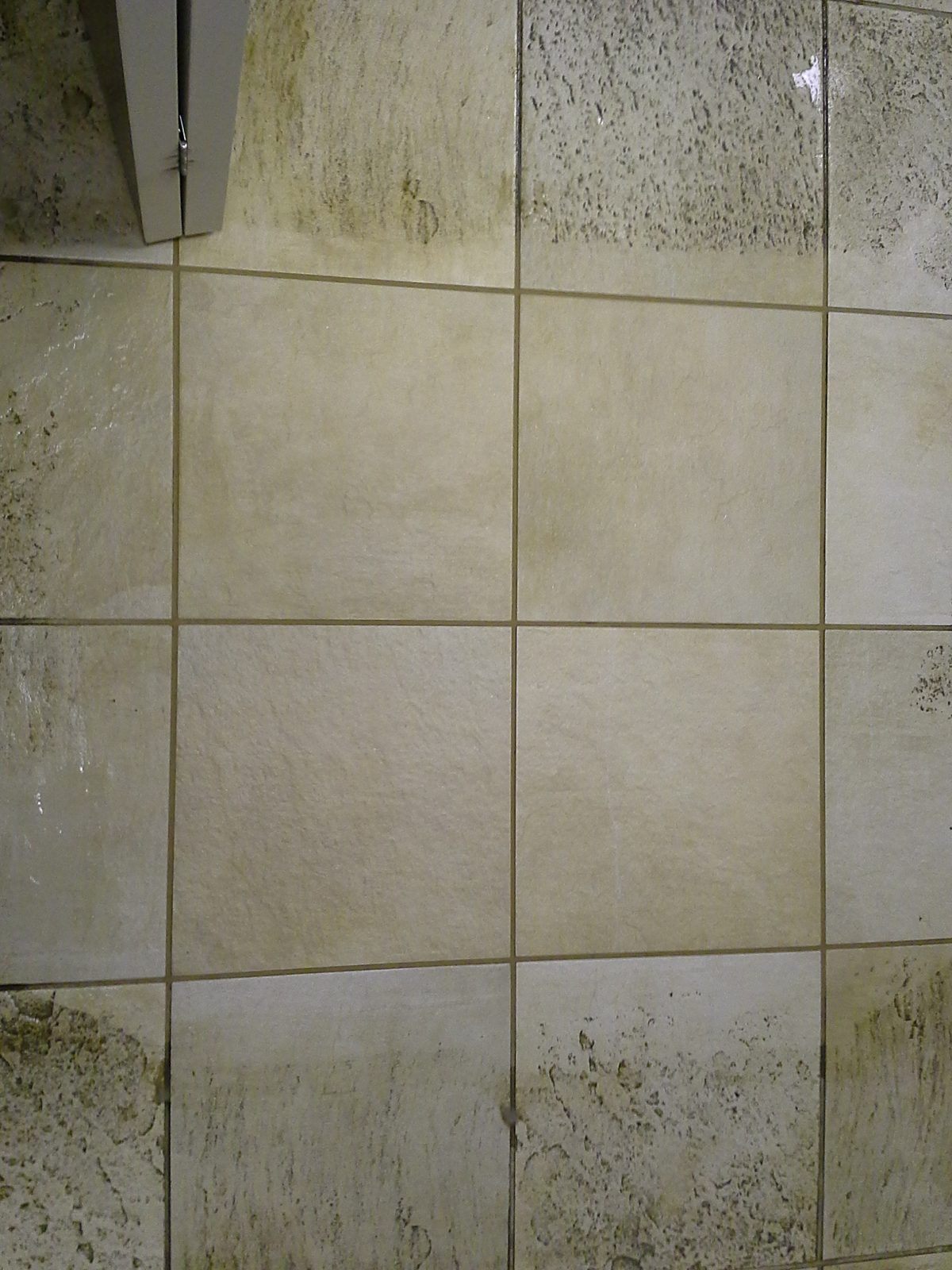 Office kitchen tile in Wellesley, MA, with the center section professionally cleaned next to uncleaned tile