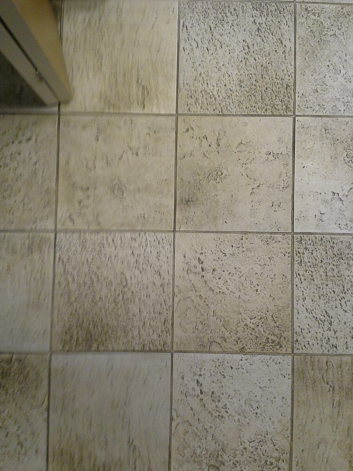 Soiled ceramic tile and grout in an office kitchen in Wellesley, MA, before professional cleaning