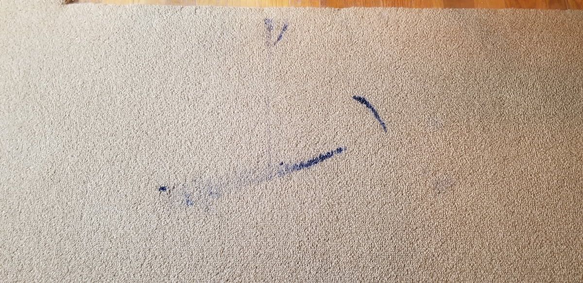 Severe printer ink stain on wool beige carpet before expert stain removal by IICRC Master Textile Cleaner in Woburn, MA